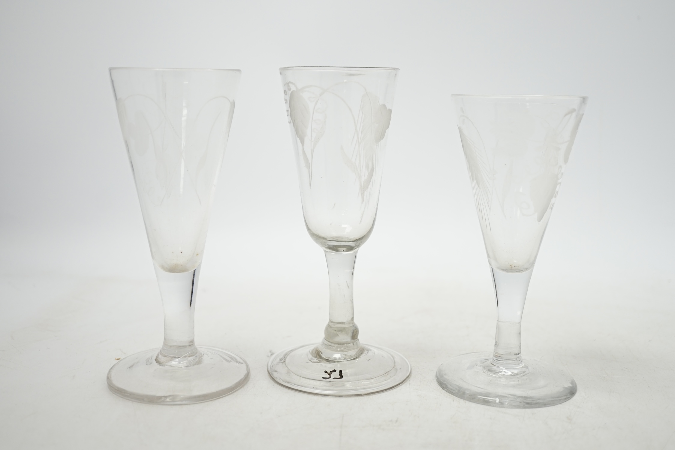 Three mid 18th century engraved ale glasses, all with hop decoration to the bowls, 14cm. Condition - good